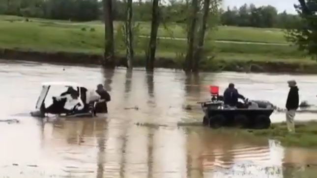 Golfers dragged out of water whilst still in their golf cart